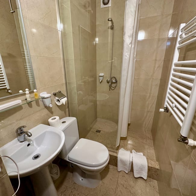 Moldova chisinau hotel bathroom with shower, sink, and neatly folded towels