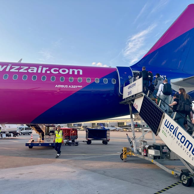 Passengers board a wizz air airbus at chisinau airport in moldova under a blue sky