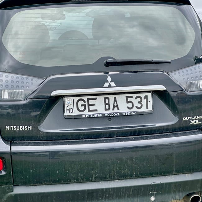 Moldova, chisinau road conditions: parked mitsubishi outlander xl with rain-speckled rear bumper and license plate