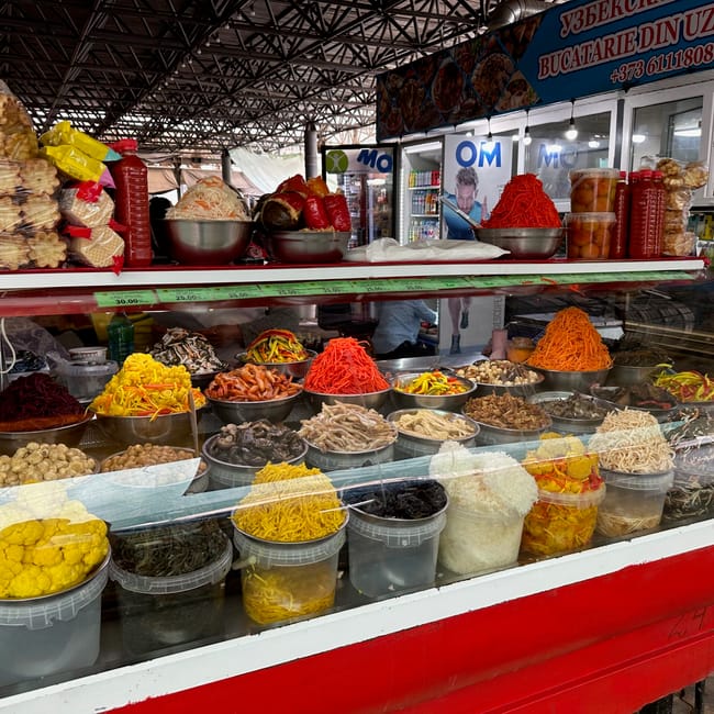 Food stall in chisinau foods, moldova with bowls of colorful pickled vegetables and pastries under a market canopy