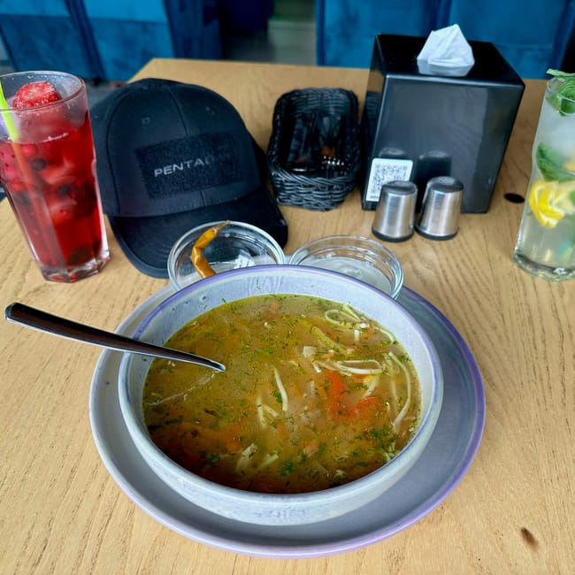 Moldova, chisinau foods table with a bowl of soup, iced drinks, and meal condiments