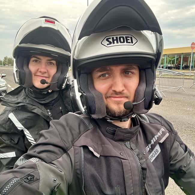 Dwoje motocyklistów w kaskach robi selfie przy drodze podczas wyprawy desert horizons motorcycle expedition.