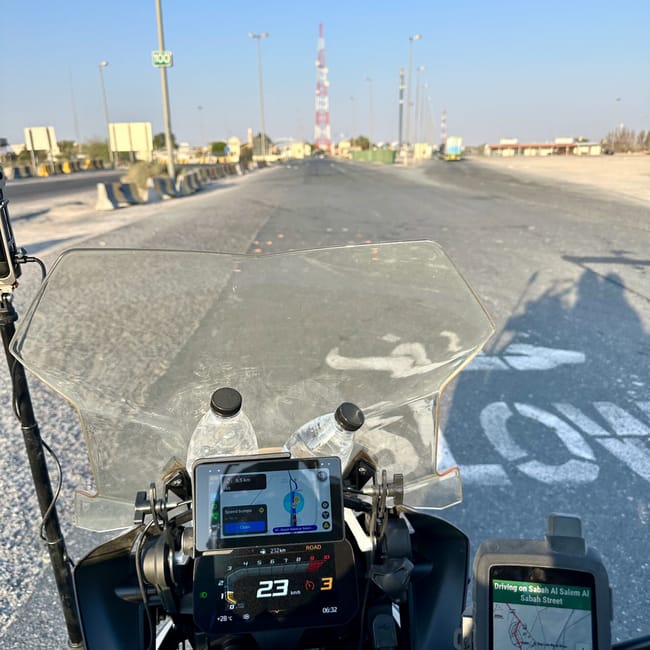 View from a motorcycle dashboard on the desert horizons motorcycle expedition route in kuwait, with highway lights ahead