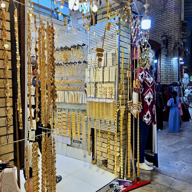 Sklep z biżuterią w erbil qaysari bazaar z wiszącymi złotymi łańcuszkami i manekinami przy wejściu