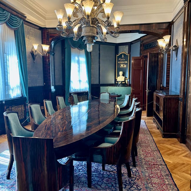 Interior of turkey’s ankara economic independence museum with a large chandelier, ornate curtains, and formal meeting table