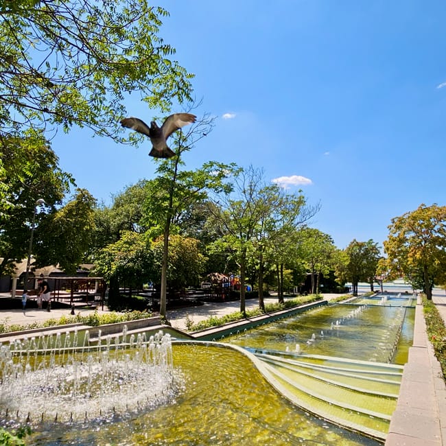 A bird statue flying above fountains in ankara genclik park, turkey