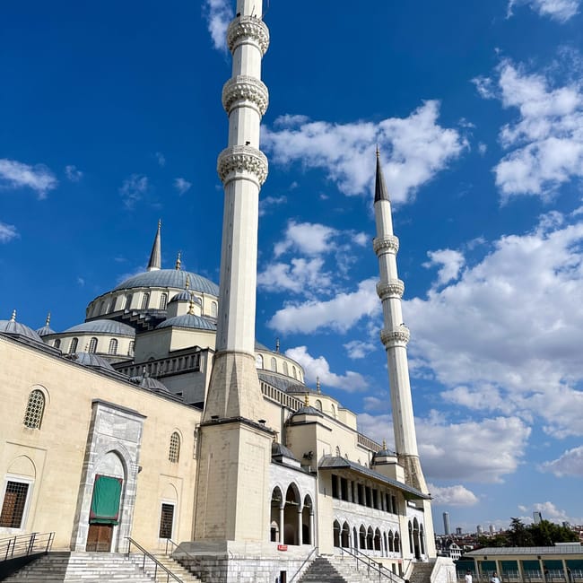 Turkey, ankara kocatepe mosque with tall minarets and domed roof against a blue sky with clouds