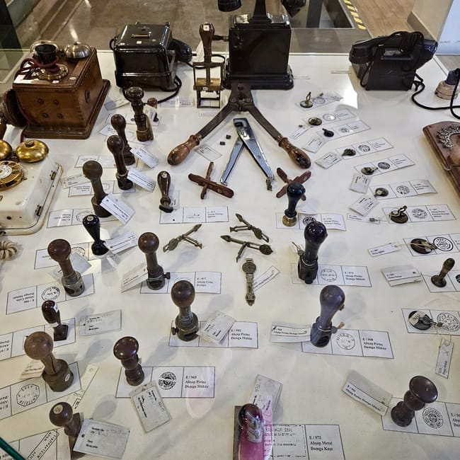 Antique postal stamps display at turkey’s ankara ptt stamp museum, with metal postmark stamps on white cards