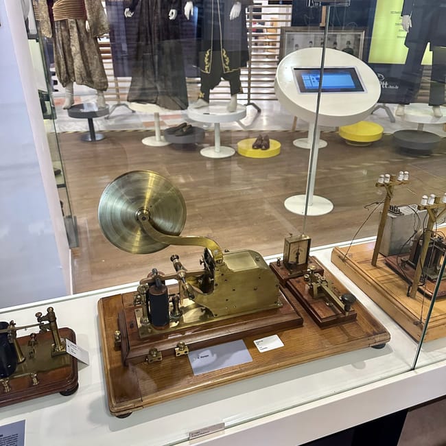 An exhibit at turkey’s ankara ptt stamp museum showing a brass printing press with cymbal-like wheel components