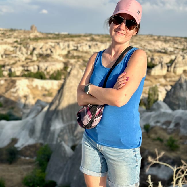 Kobieta na tarasie widokowym göreme w turcji, z skalnym krajobrazem w tle.