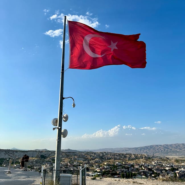 Flaga turcji na punkcie widokowym goreme observation deck nad krajobrazem kapadocji