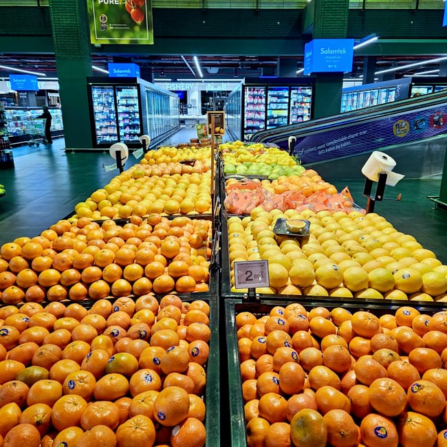 Kuwait, foods supermarket display of fresh fruits and vegetables, including oranges, lemons, and grapes.