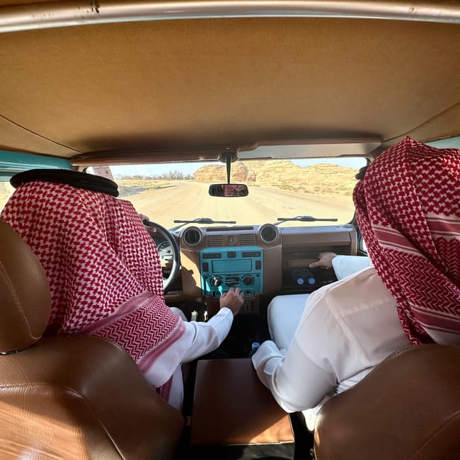 Saudi arabia, al ula hegra transport by land rover—chauffeurs in traditional headscarves driving through desert landscape