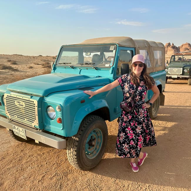 Woman posing beside a land rover during transport to al ula hegra in saudi arabia
