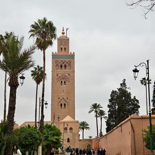 Koutoubia mosque in marrakesh, morocco, with palm trees and a walkway leading to its minaret