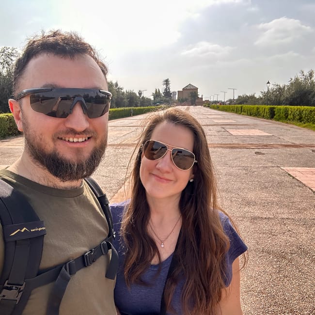 Couple wearing sunglasses taking a selfie on the walkway at menara gardens in marrakesh, morocco