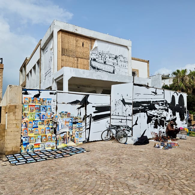Plac moulay hassana w essaouirze w maroku, białe murale i stragany z pamiątkami na brukowanym placu