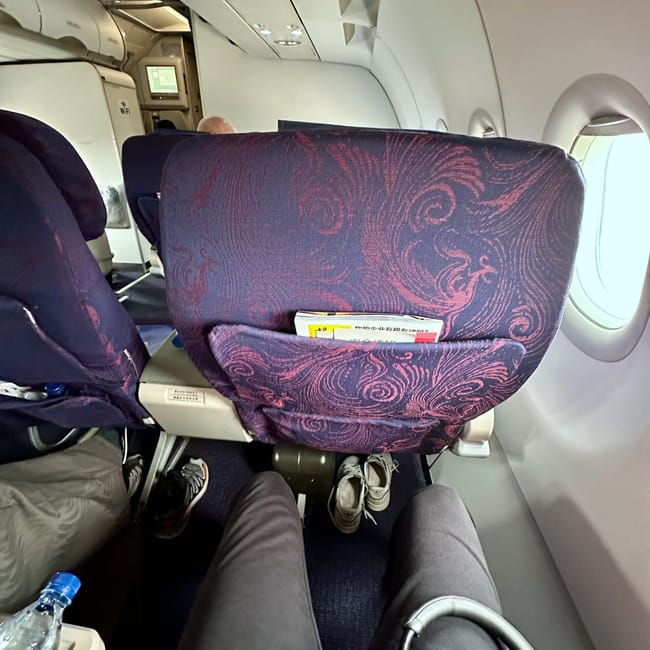 Wnętrze kabiny biznesowej air china w trakcie lotu, widok na fioletowe fotele i okna samolotu