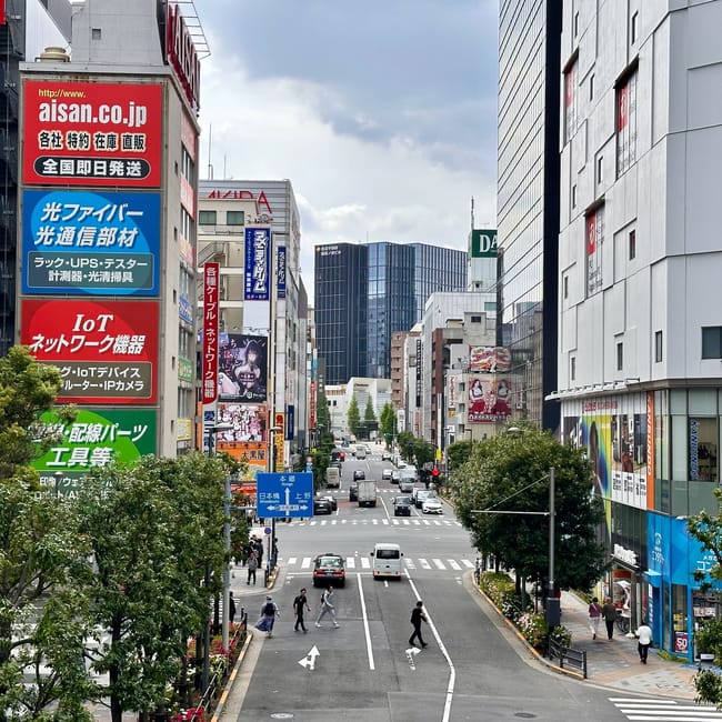 Akihabara w tokio: ruchliwa ulica z wysokimi budynkami i japońskimi szyldami reklamowymi