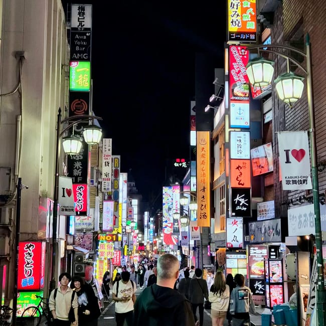 Kabukicho w tokio nocą, zatłoczona ulica pełna neonowych szyldów i pieszych