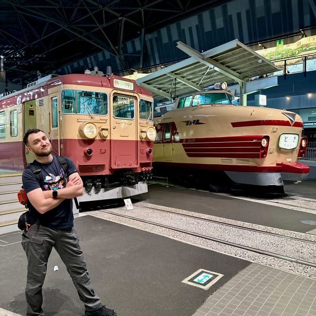 W tokio w railway museum mężczyzna stoi przed dwoma zabytkowymi pociągami
