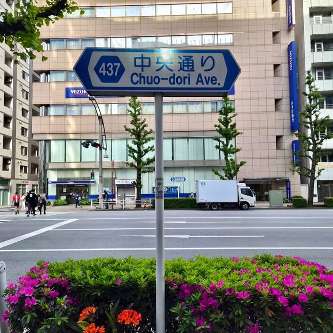 Znak drogowy chuo-dori ave. W tokio na tle miejskiej ulicy i budynków biurowych