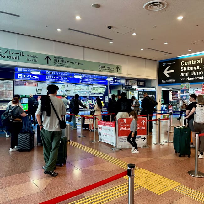 Kasa biletowa tokyo monorail na lotnisku haneda w tokio z kolejką pasażerów i tablicami informacyjnymi