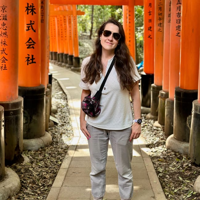 Jadzia w fushimi inari-taisha w kioto, stojąca między pomarańczowymi bramami torii