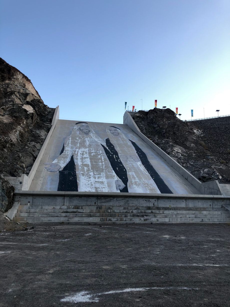 Hatta dam w zea z muralem na betonowym zboczu i skalnymi zboczami po bokach