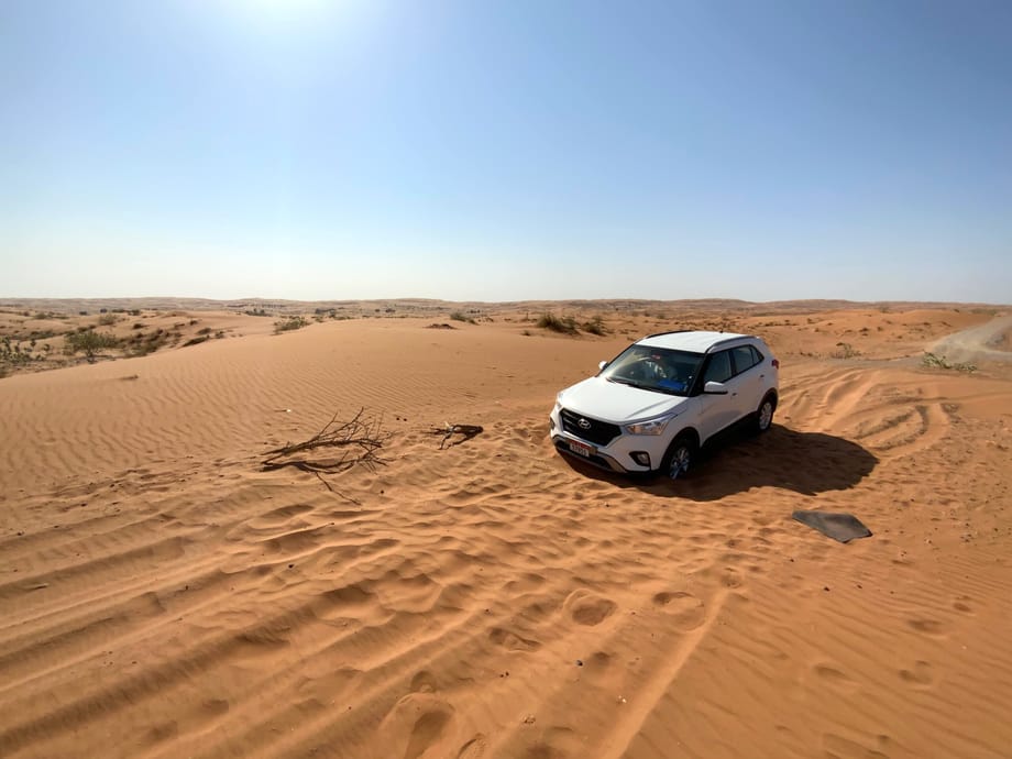 Biały suv na pustynnych wydmach w dubaju