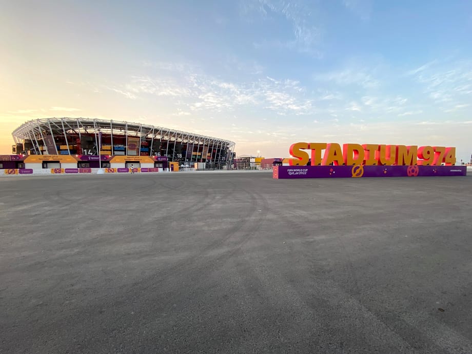 Stadium 974 w dosze o wschodzie słońca, z dużym napisem przed stadionem