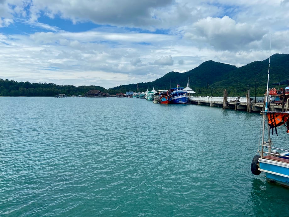 Przystań na koh chang w tajlandii z łodziami i górami w tle