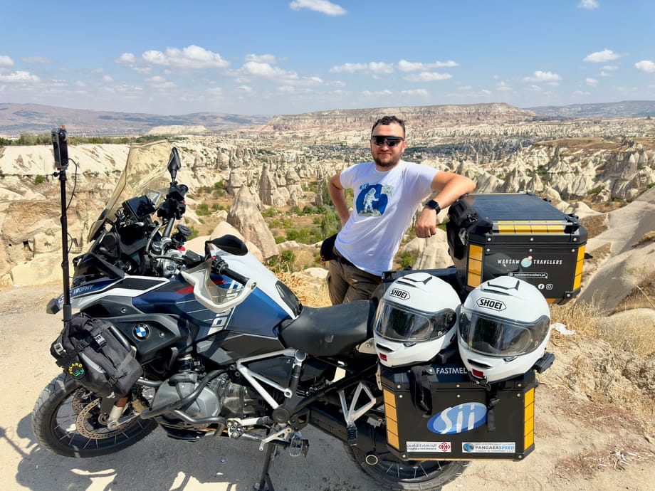 Filip przy motocyklu w kapadocji, z widokiem na skaliste doliny.