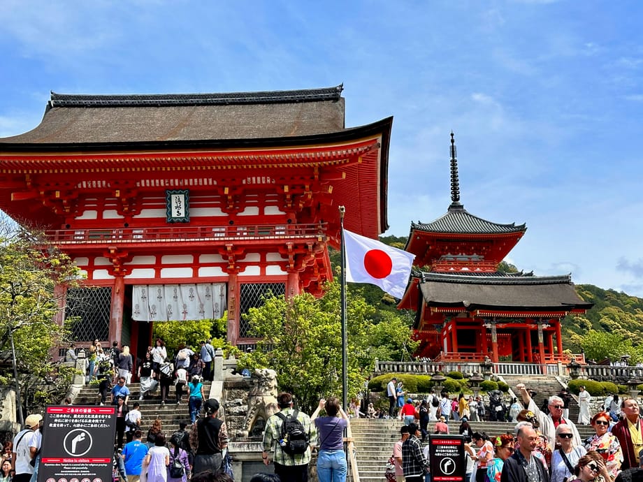 Kiyomizu-dera temple w kioto z tłumem turystów i japońską flagą