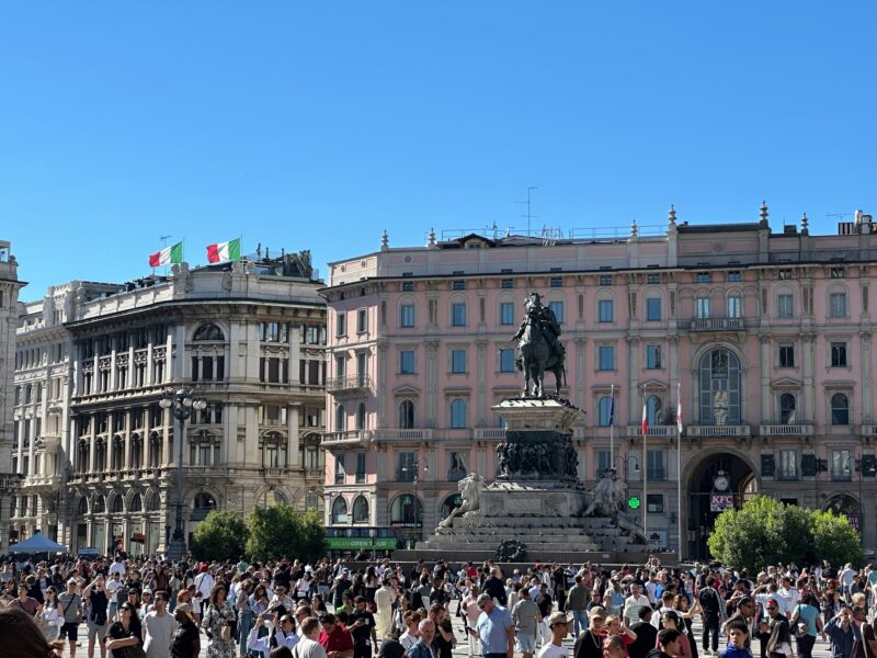 Piazza del duomo w mediolanie z pomnikiem i tłumem turystów