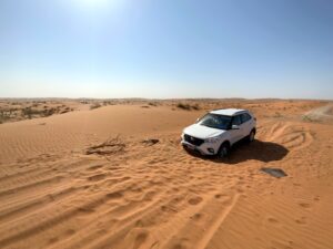 Biały suv na pustynnych wydmach w dubaju