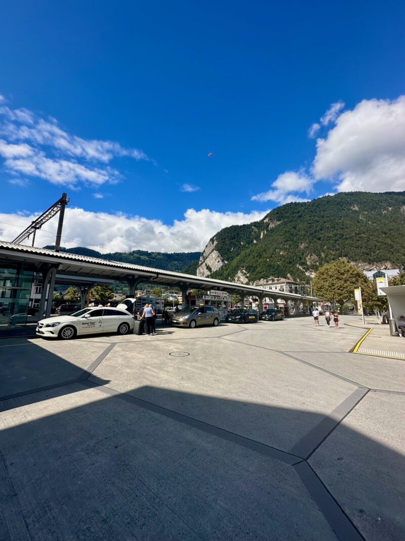 Dworzec w interlaken z peronami, taksówkami i górami w tle pod błękitnym niebem