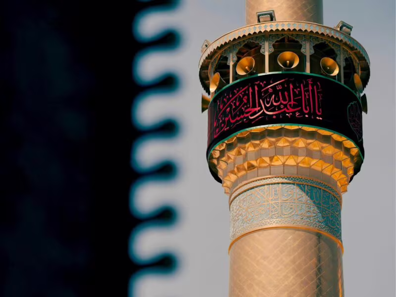 Ozdobny minaret w iraku z arabskimi napisami i głośnikami na szczycie