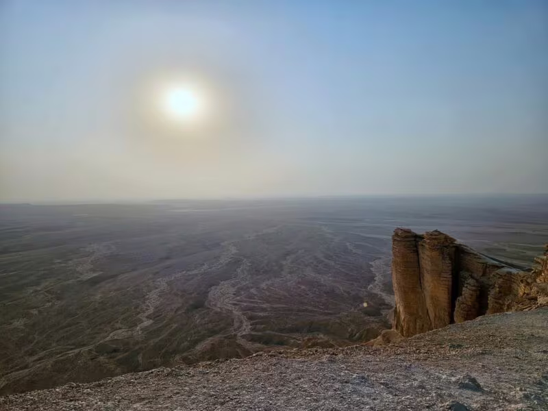 Klif edge of the world w arabii saudyjskiej z widokiem na rozległą pustynię skąpaną w słońcu