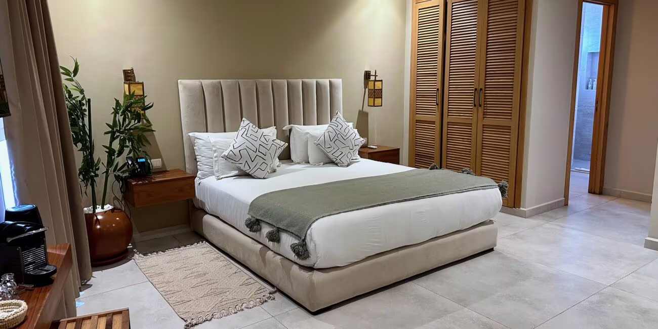 Maroko, essaouira: hotel, nasz nocleg – nowoczesna sypialnia z dużym łóżkiem i drewnianymi drzwiami