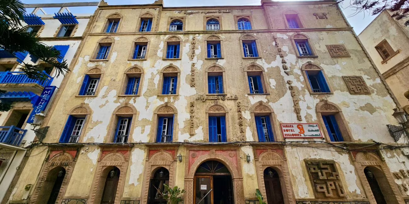 Essaouira, medina: zabytkowa fasada budynku hotelowego z oknami i szyldem sahara hotel essaouira