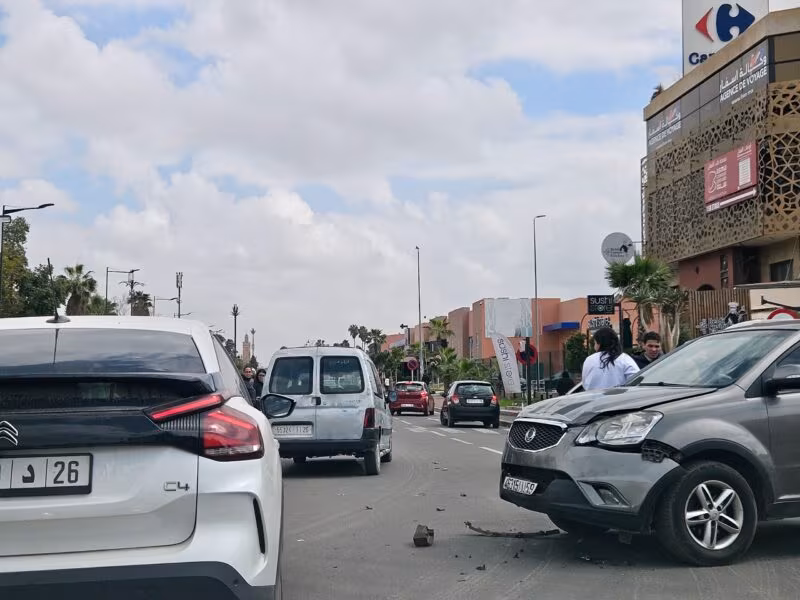 Wypadek drogowy w marrakeszu: dwa auta po kolizji na ulicy, z rozrzuconymi odłamkami na jezdni. Maroko