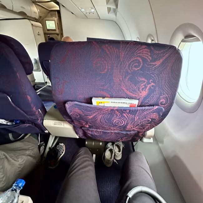 Wnętrze kabiny biznesowej air china w trakcie lotu, widok na fioletowe fotele i okna samolotu