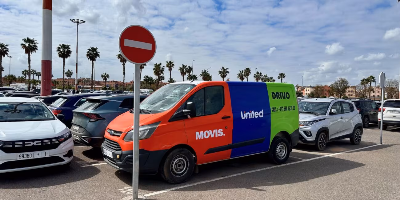 Parking w marrakeszu z kolorowym vanem wypożyczalni i znakiem zakazu wjazdu