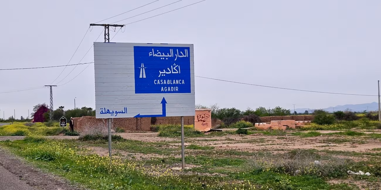 Drogowskaz w maroku wskazujący casablankę, agadir i sidi bou othmane, przy wiejskiej drodze