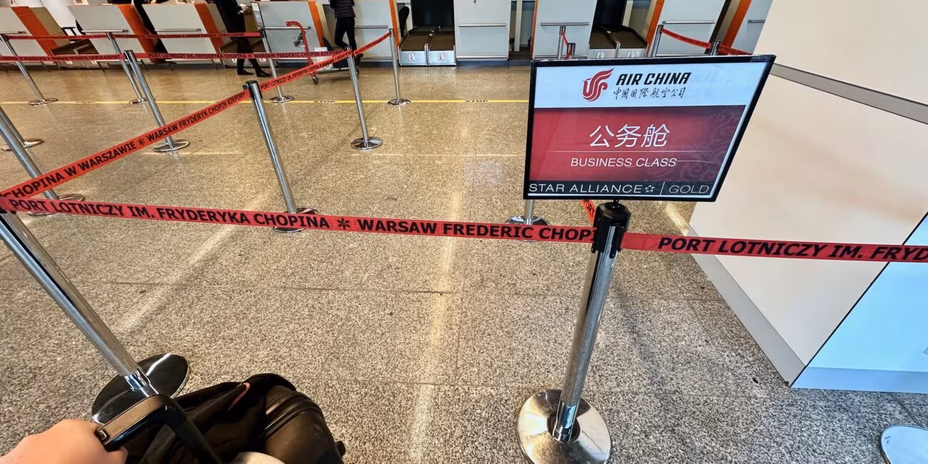 Kolejka do odprawy biznes klasy na lotnisku chopina w warszawie, z oznaczeniem air china i star alliance gold